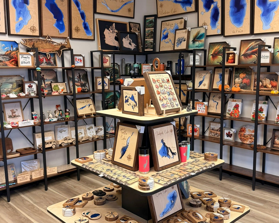 Art gallery with various framed artworks on the walls and display tables.